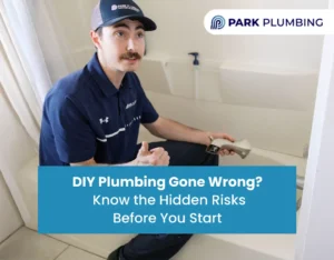 Homeowner attempting DIY plumbing under a sink with tools scattered, representing plumbing risks.